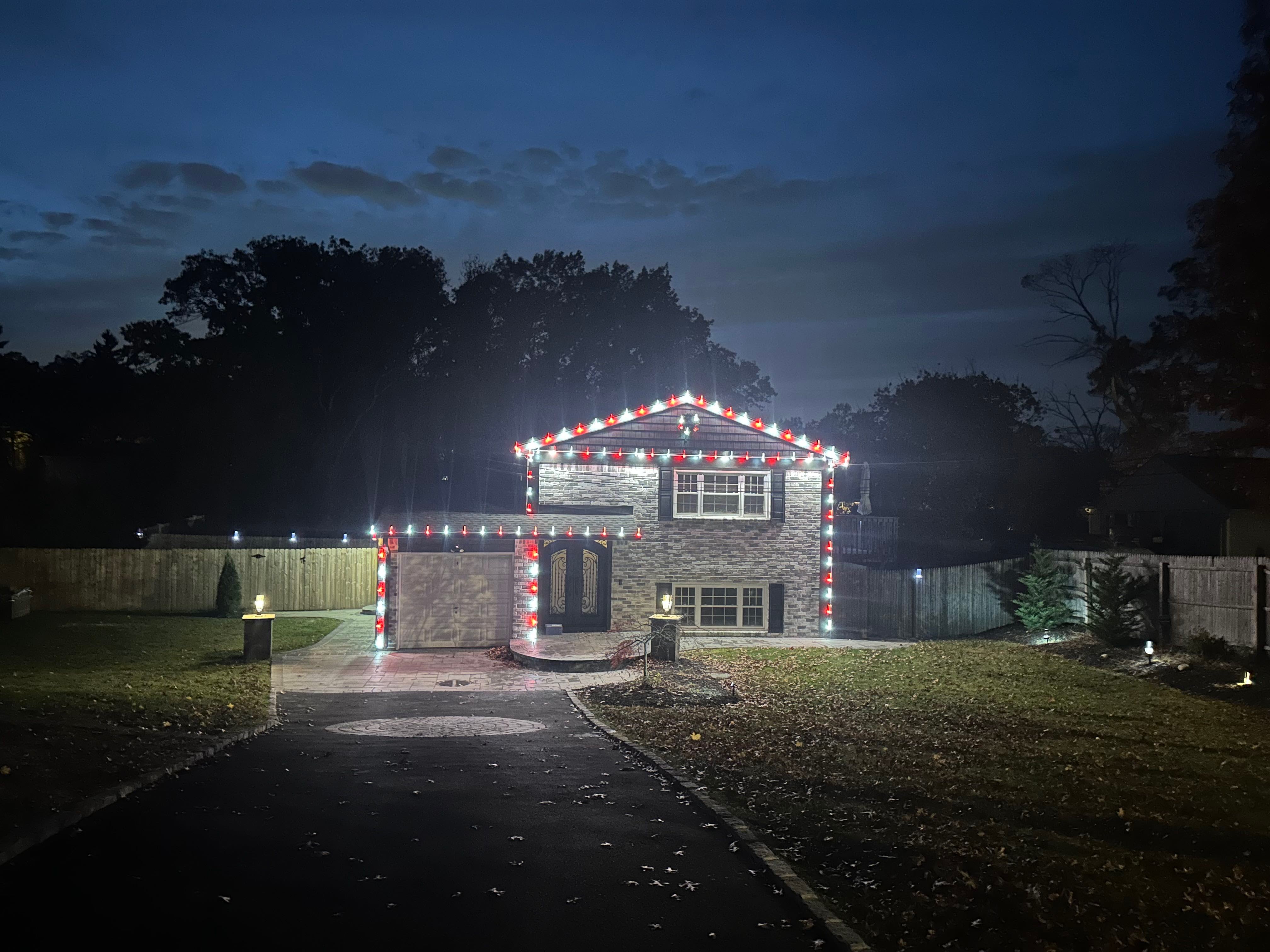 A home decorated with red and white roofline lights.