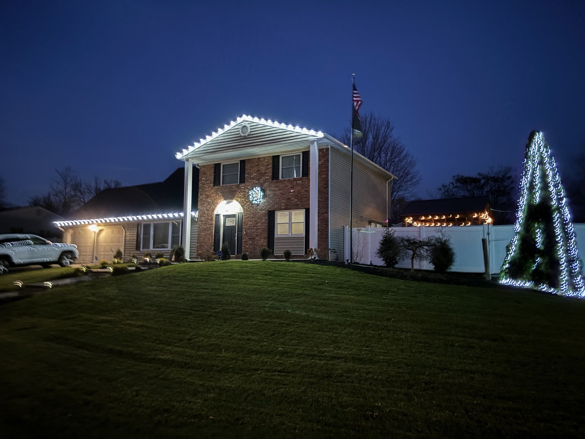 A large tree wrapped in warm white Christmas lights.